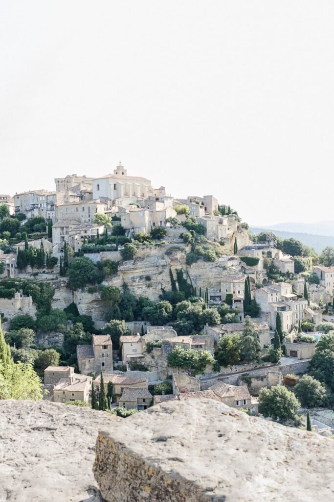 Vue emblématique du village perché de Gordes en Provence, maisons de pierre, cyprès et église dominant la falaise calcaire du Luberon